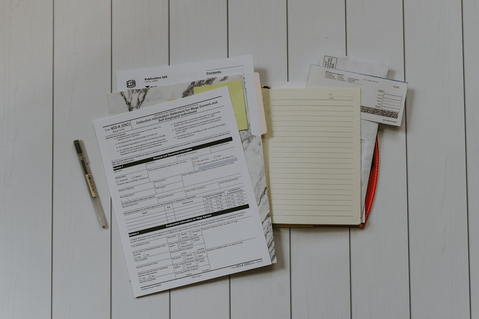 Open notebook listing personal finance rules with a pen and coffee on a desk